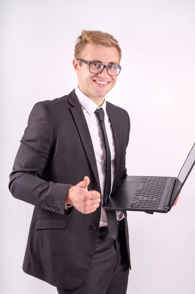 El hombre de negocios hermoso que trabaja en el portátil y muestra bien — Foto de Stock