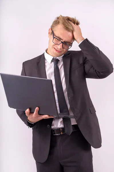 Den vackra affärsmannen arbetar på laptop och mycket upprörd — Stockfoto