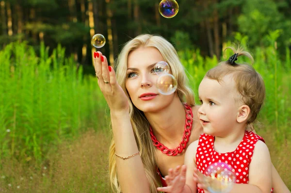 Happy matka a dítě s mýdlové bubliny — Stock fotografie