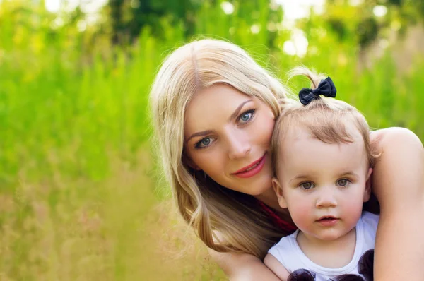 Gelukkig moeder en baby op aard achtergrond — Stockfoto