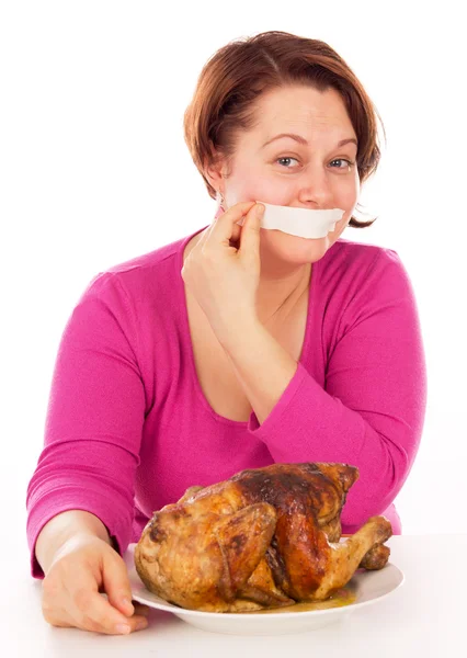 Full woman on a diet does not stand up and want to eat chicken — Stock Photo, Image
