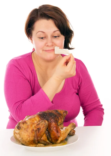 Full woman on a diet does not stand up and want to eat chicken — Stock Photo, Image