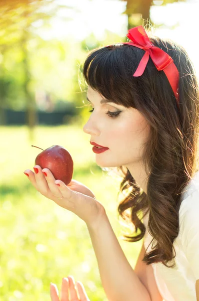 Schönes Mädchen schaut auf Apfel — Stockfoto