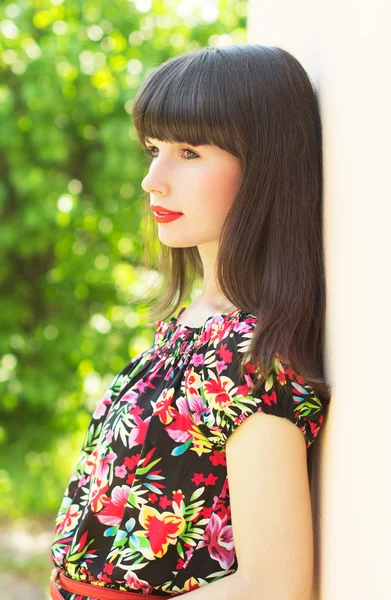 Menina bonita fica perto da parede — Fotografia de Stock