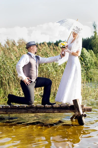 Mooie bruid en bruidegom op de brug — Stockfoto