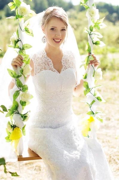 Beautiful bride on a swing — Stock Photo, Image