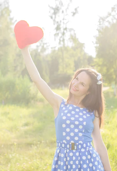 Krásná dívka drží vysoko nad jeho hlavou srdce — Stock fotografie