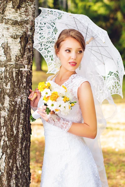 Beautiful young bride standing in the woods — Stock Photo, Image