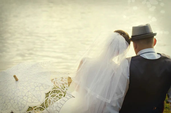 Nevěsta a ženich na pozadí vody — Stock fotografie