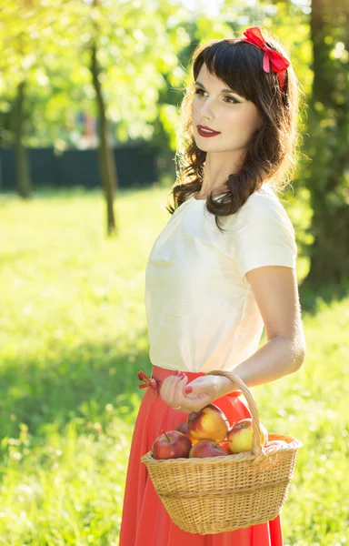 Chica sosteniendo una cesta de manzanas — Foto de Stock