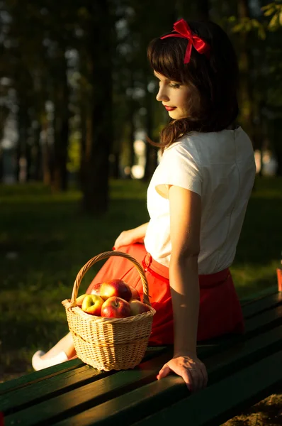 Fille dans une prairie sous un arbre assis sur le banc — Photo