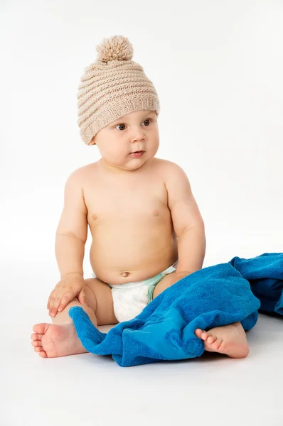 Happy kid in a cap and towel sitting — Stock Photo, Image