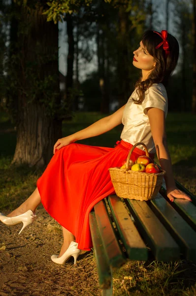 Girl in a meadow under a tree sitting on the bench Royalty Free Stock Images