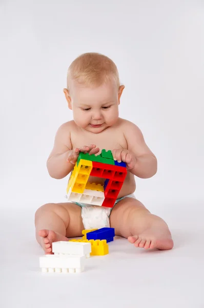 Happy baby playing in the constructor sitting on the floor Stock Image