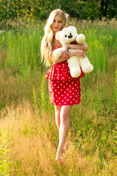 Струнка молода дівчина з плюшевим ведмедем на природі — стокове фото