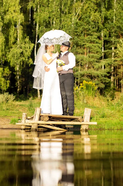 The bride and groom are standing on the bridge — Stock Photo, Image