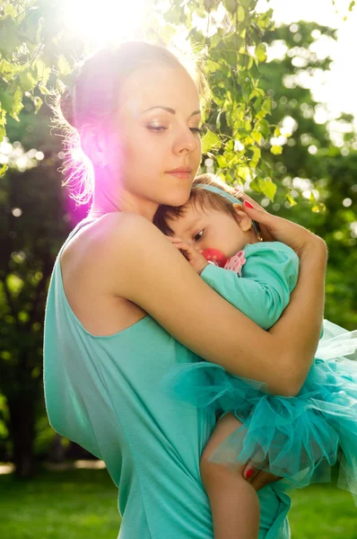 Maman étreint bébé au coucher du soleil — Photo