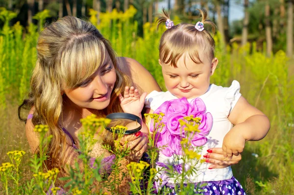 Anne ve kızı bir büyüteç altında doğa eğitimi — Stok fotoğraf