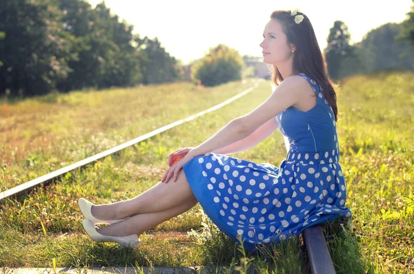 Mooi meisje, zittend op de rails Stockfoto