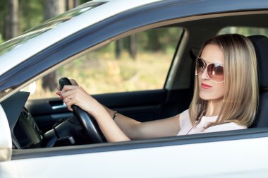 Arabanın direksiyonuna oturan güzel kız