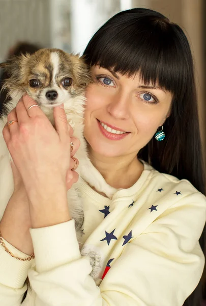 Una ragazza tiene un cane tra le braccia — Foto Stock