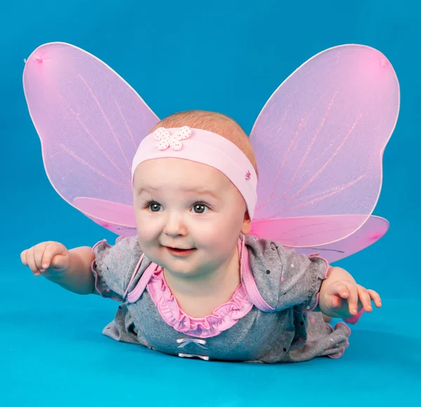 Happy small girl butterfly wings sitting on the floor — Stock Photo, Image