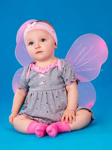 Niña alas de mariposa sentada en el suelo — Foto de Stock