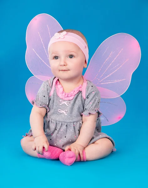 Niña alas de mariposa sentada en el suelo — Foto de Stock