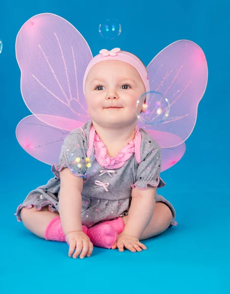 Kleines Mädchen Schmetterlingsflügel auf dem Boden sitzend — Stockfoto
