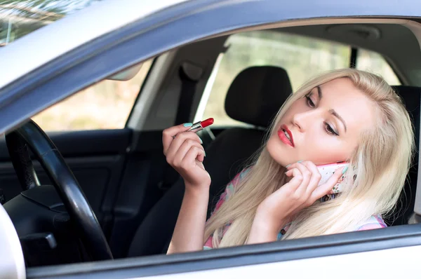 Chica pinta sus labios y hablar mientras conduce — Foto de Stock