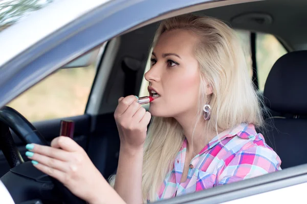 Ragazza dipinge le labbra al volante l'auto — Foto Stock