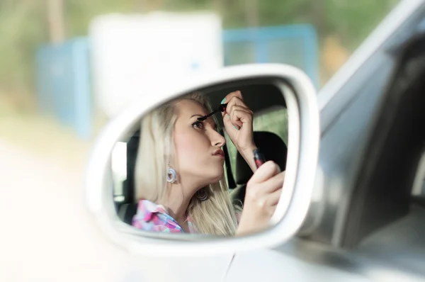 Mädchen malt die Wimpern für das Autofahren — Stockfoto