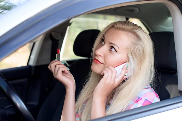 El uso de cosméticos y chat en el teléfono durante la conducción — Foto de Stock