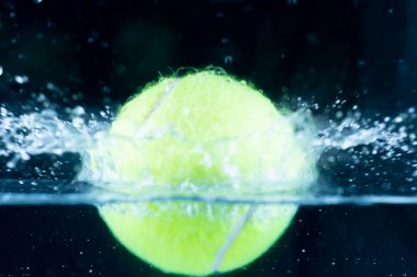 Tennis ball in water Splashing water dropletssoft focus.