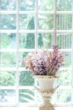 Pencerenin yanında duran kurumuş çiçek vazosu. Yumuşak odak noktası. Klasik tarz..