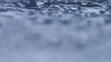 Yakın plan su kabarcığı ya da temiz bardakta kaynayan su. Siyah bir arkaplanda. Yumuşak odaklanma.