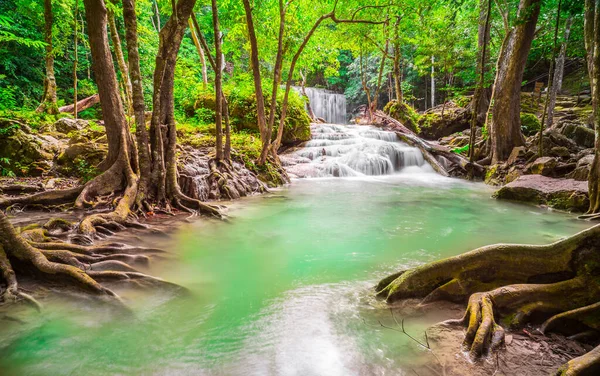 Waterfalls and fish swim in the emerald blue water in Erawan National Park. Erawan Waterfall is a beautiful natural rock waterfall in Kanchanaburi, Thailand.Onsen atmosphere. Fresh nature.4K