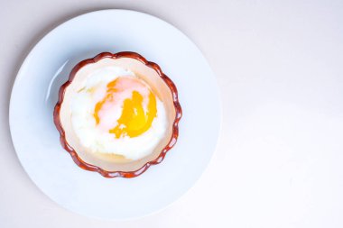 Tabakta kızarmış yumurta, beyaz arka planda, Onsen yumurtaları seramik bardakta..