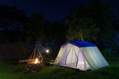 Gece vakti doğa tarafından çevrelenmiş bir ormanda kamp çadırında.