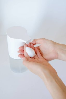 Kadınlar el yıkama jeli ya da antibakteriyel sabun dezenfektanı kullandıktan sonra kamuya açık alanda temizlik konsepti kullanırlar.