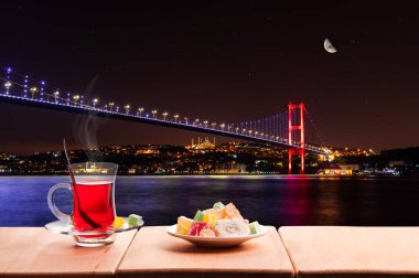 Aydınlatılmış Boğaz Köprüsü ve geleneksel Türk çayı, İstanbul