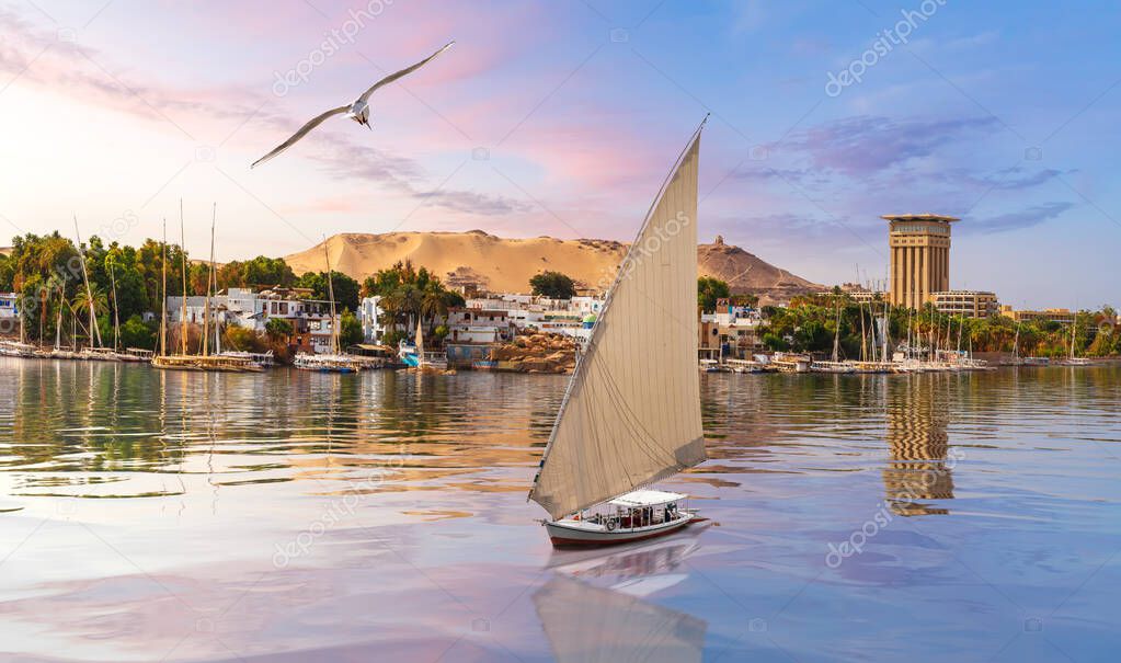 Beautiful view of the Nile river and a sailboat by the city of Aswan, Egypt
