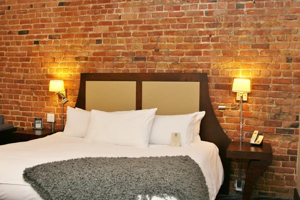 Luxury bedroom with a brick wall — Stock Photo, Image