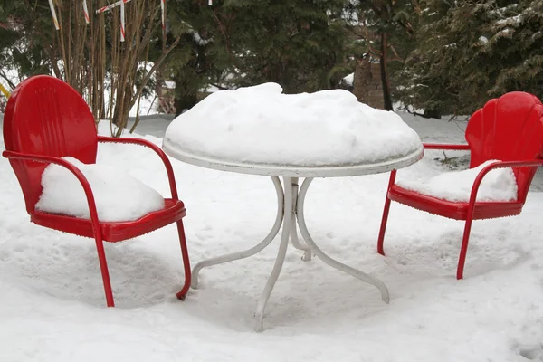 Röda stolar och bord i snö — Stockfoto