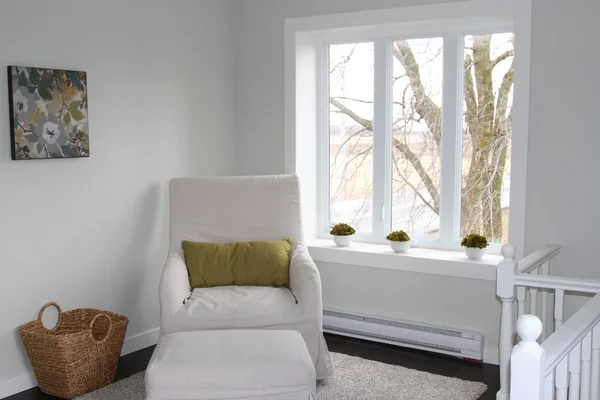 Linen sofa chair with green pillow near a large window — Stockfoto