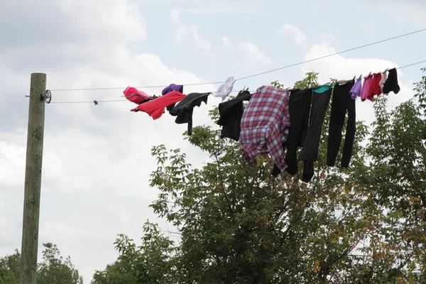 Roupas coloridas penduradas em uma linha — Fotografia de Stock