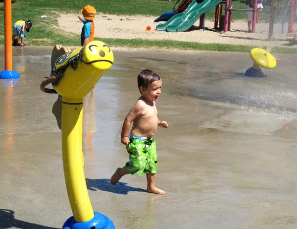 Gelukkige jongen speelt in een waterpark — Stockfoto