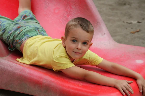 Young boy at the bottom of slide — Stock Photo, Image