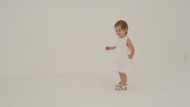 白いドレスの女の子は色のボールで遊んでいる スローモーション — ストック動画