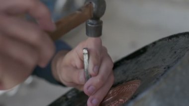 Buhara ustası kalıpları tepsiye oyuyor. Yaklaşın, ağır çekim.